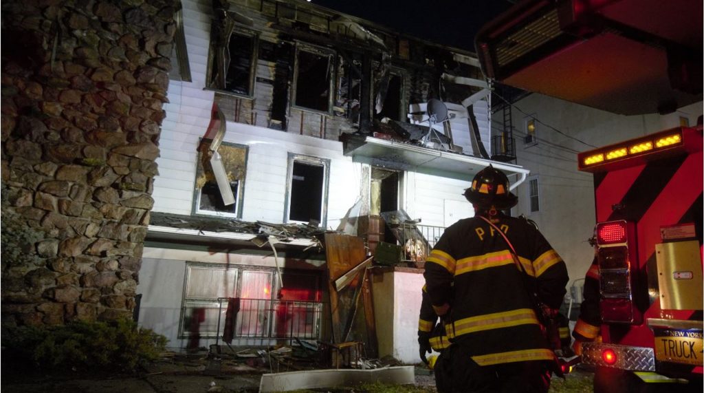Picture of Firefighter surveying the damage of a fire on Academy St